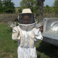DoD biologist Jacky Ferrer dons a beesuit to remove wasps from a nest box on Fort Hood, TX